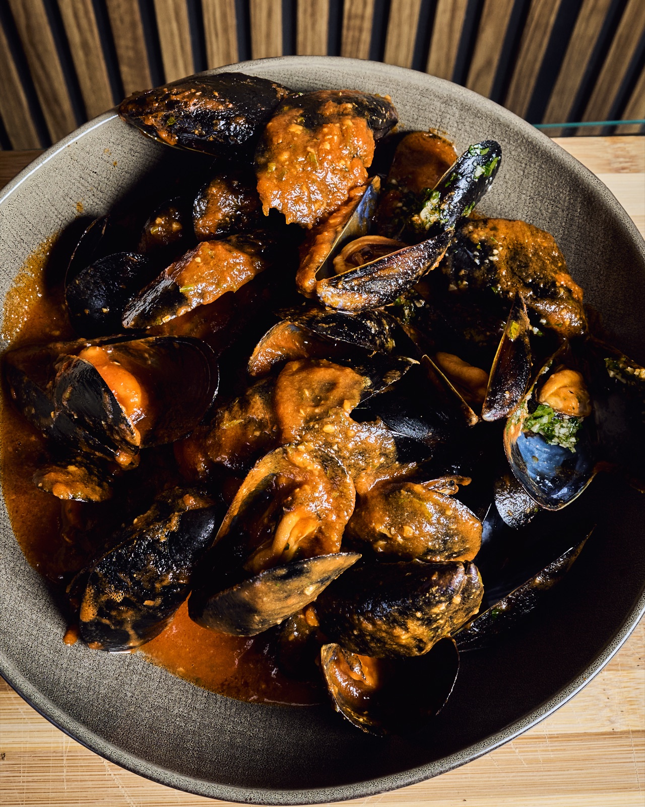 Mejillones con salsa en plato oscuro